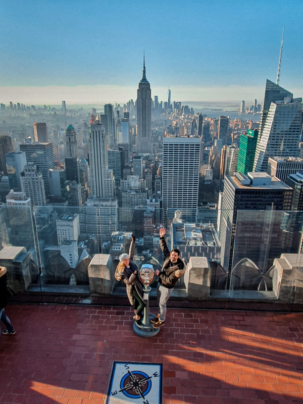 Posing on the lower deck of the Top of the Rock observation decks, while someone on the upper deck takes the picture