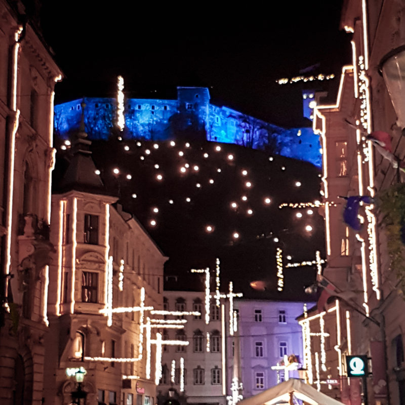 Christmas lights in the streets of Ljubljana with Ljubljana Castle in background