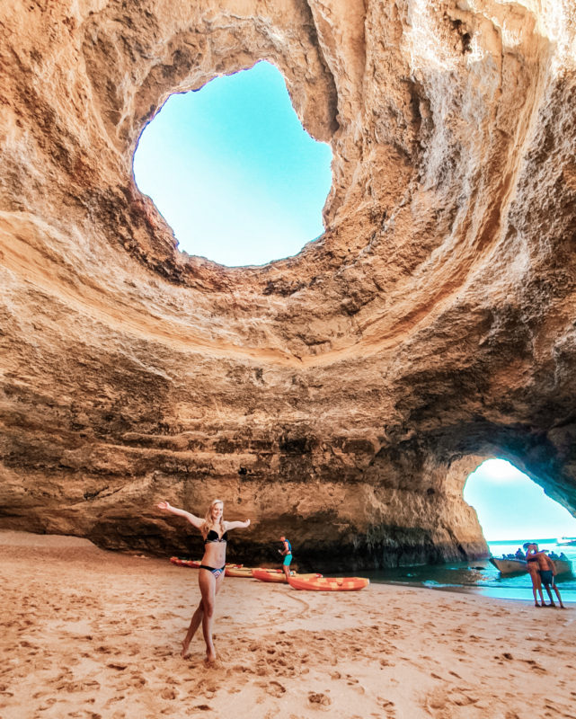 Travel girl posing inside the Benagil Caves, Algarve, Portugal