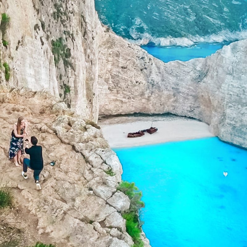 Couple getting engaged at the Shipwreck Beach Viewpoint in Zakynthos, Greece