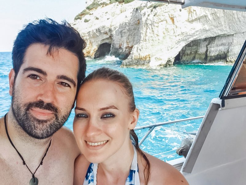 Couple taking a selfie in front of the Blue Caves during a boat tour in Zakynthos (Greece)