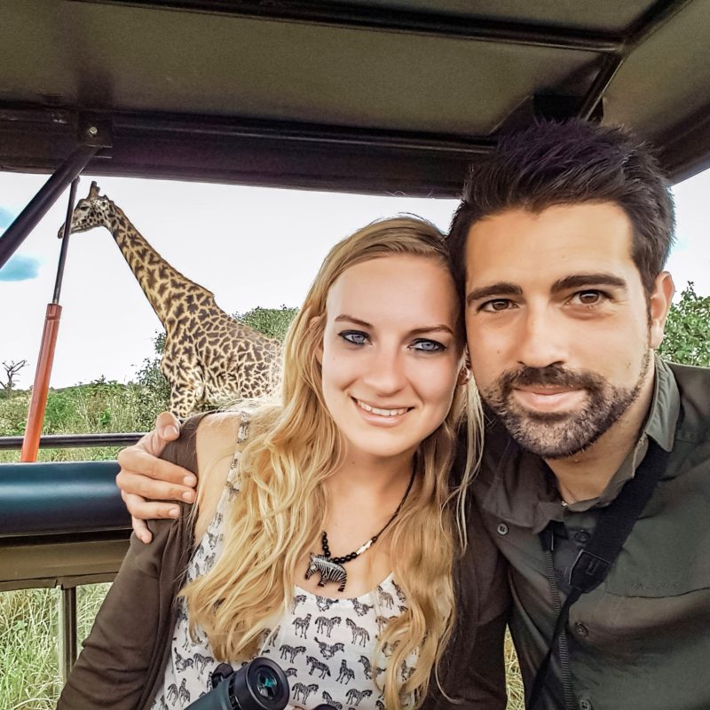Travel Couple watching giraffe at Serengeti in Tanzania