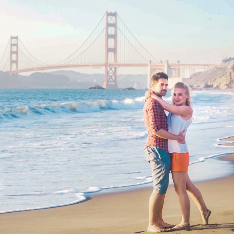 Couple photo shoot in Baker Beach, San Francisco. Golden Gate Bridge in background.