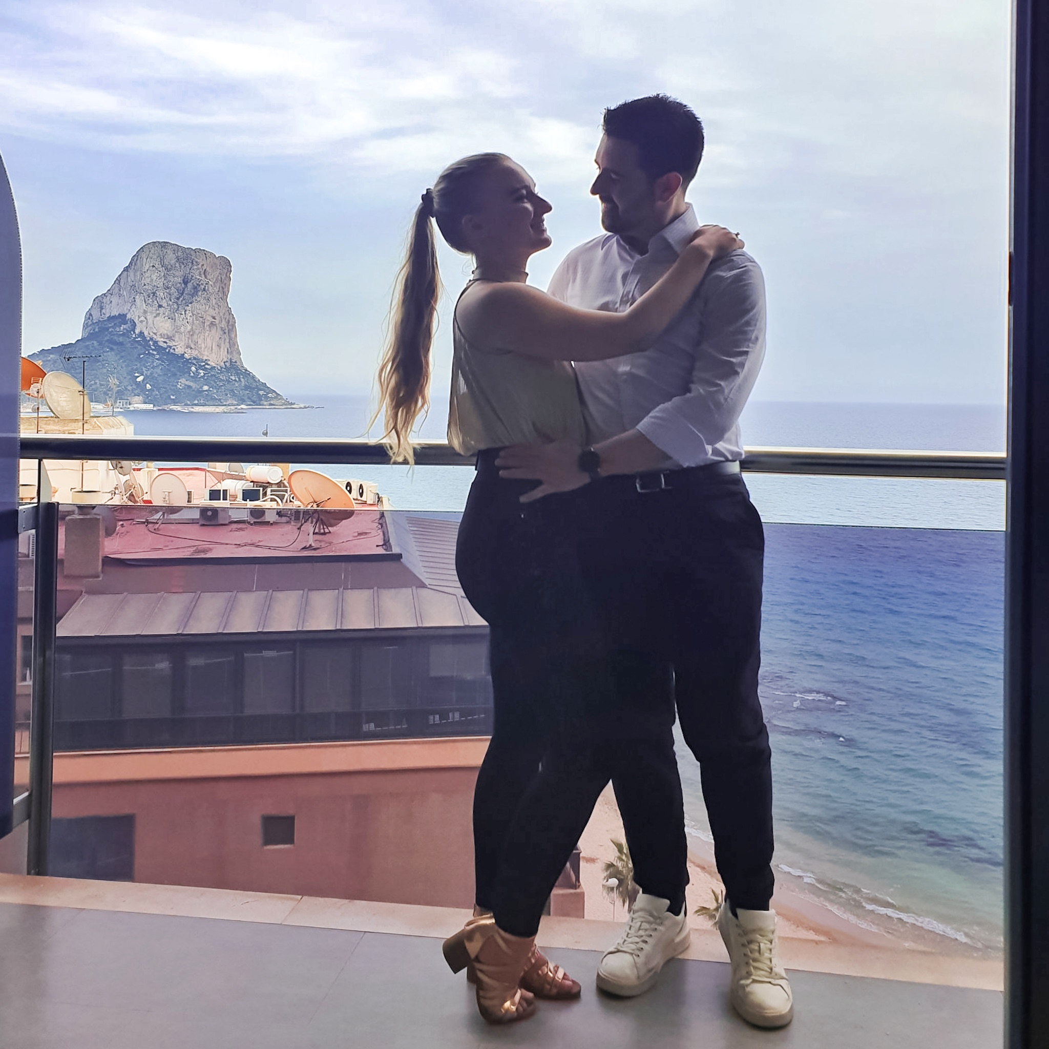 Couple posing on balcony of Sol Y Mar Hotel in Calpe, Costa Blanca Spain. With views of Ifach Rock.