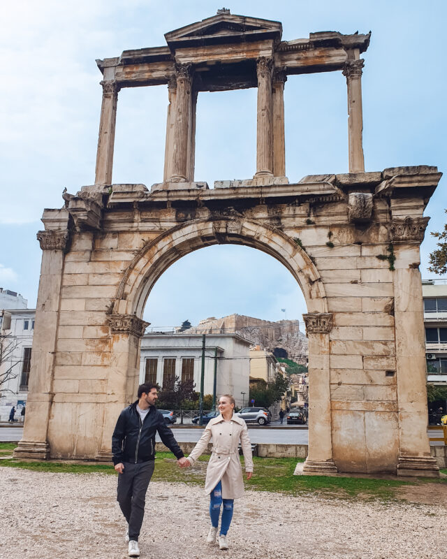 Travel couple posing in front of Hadrian's Arch in Athens, Greece