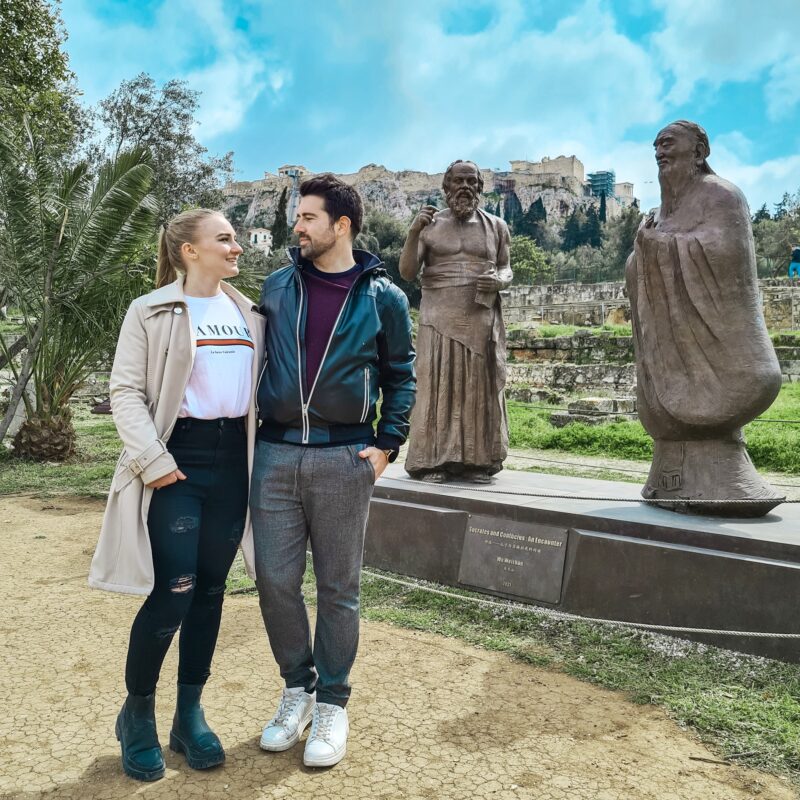 Travel Couple posing in front of the Statue of 