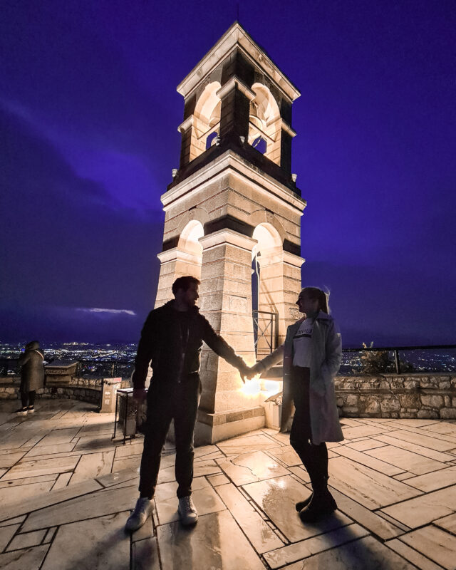 Travel couple posing near St George church on Lycabettus Hill in Athens, Greece