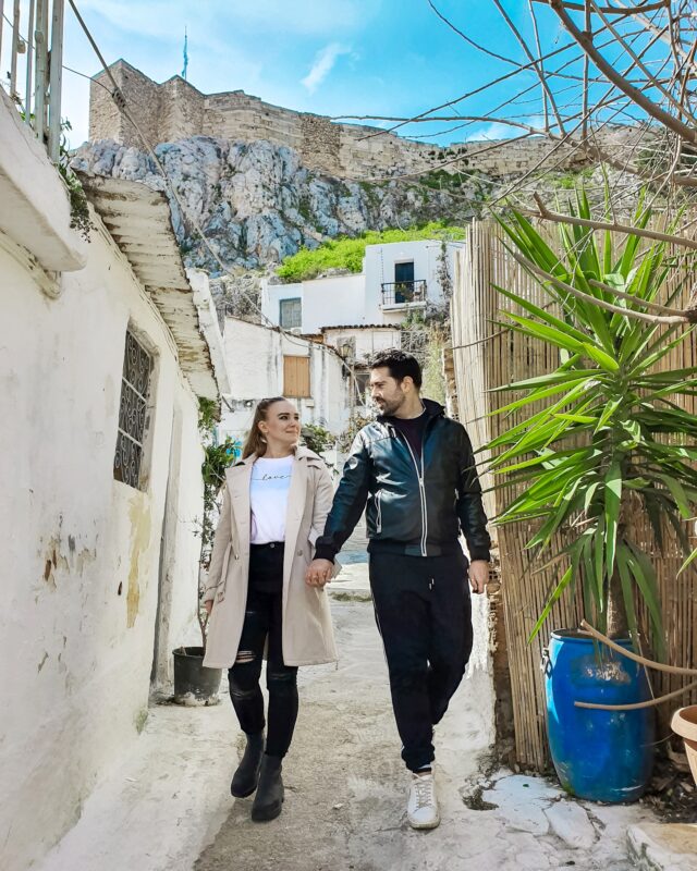Travel Couple posing in the streets of Anafiotika at the Plaka district in Athens, Greece