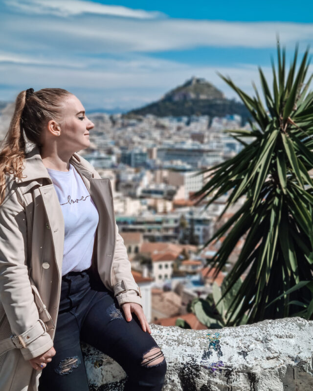 Travel girl posing at the viewpoint of Lycabettus Hill in the Plaka district of Athens, Greece