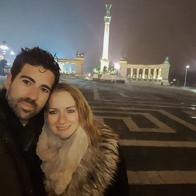 Selfie of a travel couple in front of Heroes Square in Budapest, Hungary at night