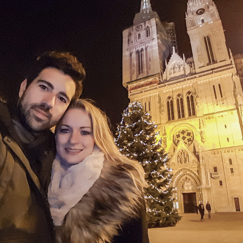 Couple posing with Christmas tree at Zagreb Cathedral, Croatia