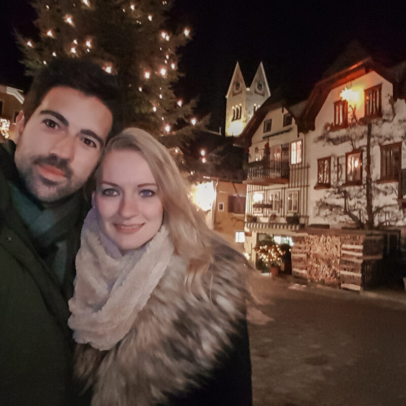 Couple posing with Christmas tree in Hallstatt, Austria