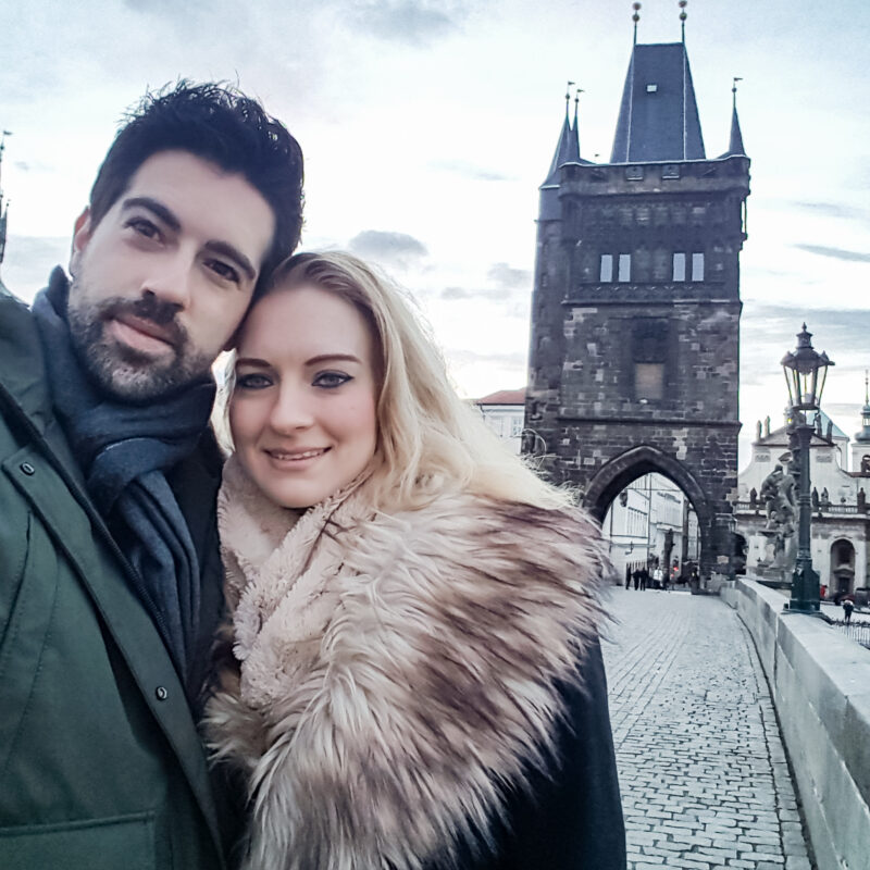 Couple posing on the Charles Bridge in Prague, Czech Republic
