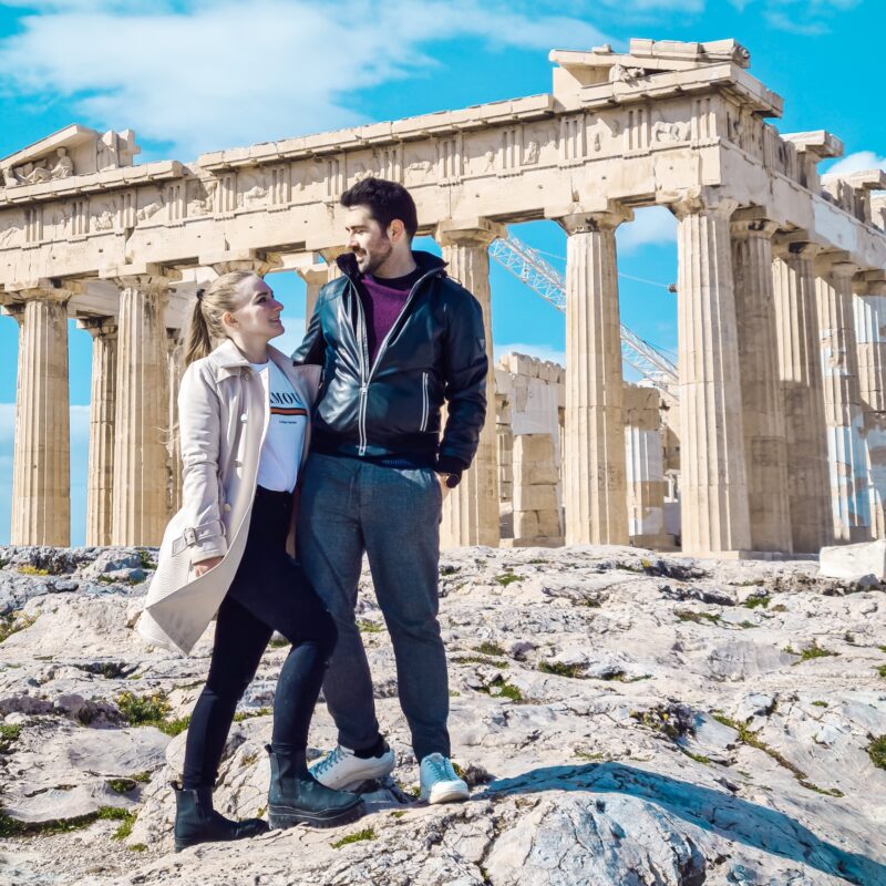 Couple posing in front of the Acropolis in Athens