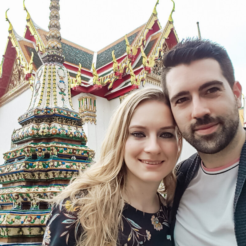 Travel Couple taking a selfie in front of Wat Pho in Bangkok, Thailand