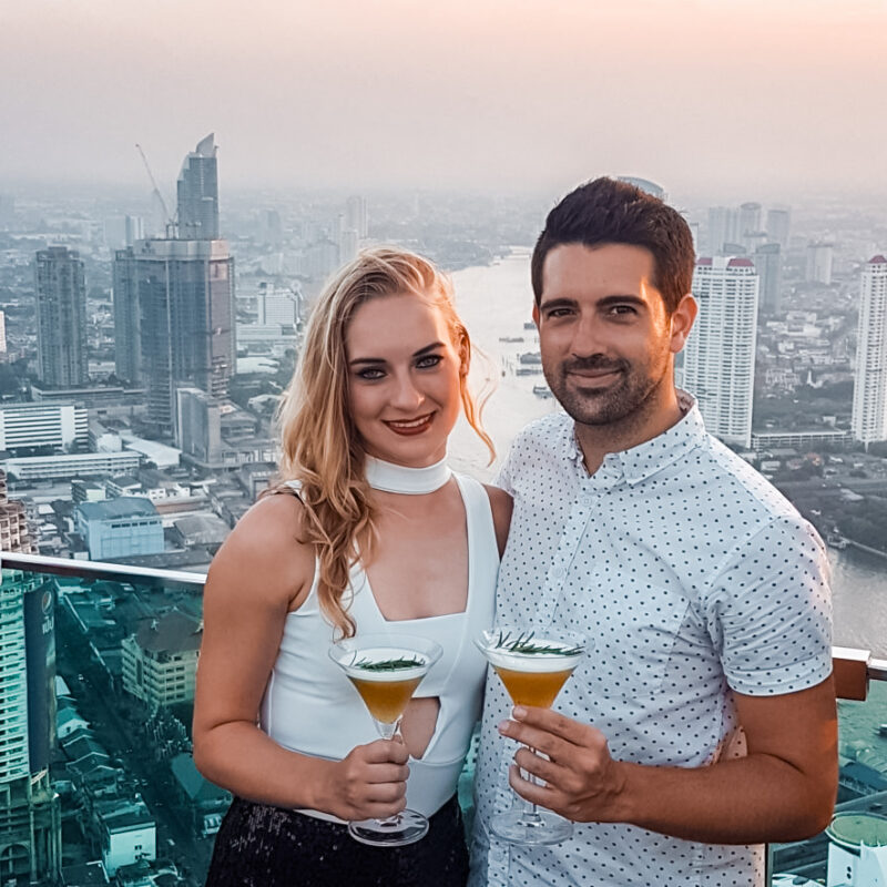 Travel Couple enjoying a Hangovertini at the Lebua Rooftop Bar in Bangkok, Thailand
