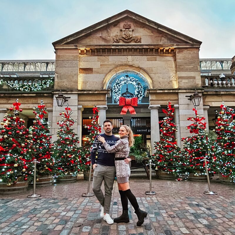 Travel Couple posing with Christmas Decorations at Covent Garden in London