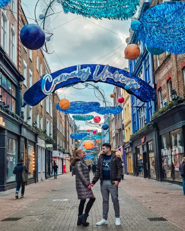 Travel Couple posing with Christmas Decorations at Carnaby Street in London