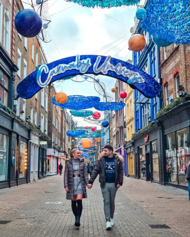 Travel Couple posing with Christmas Decorations at Carnaby Street in London