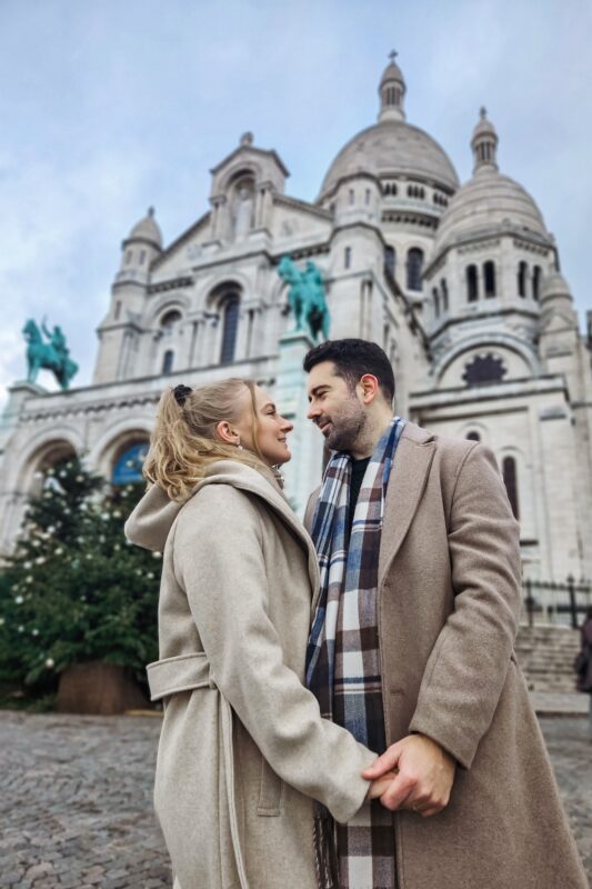 Romantic Photo Spots in Paris for Couples - Travel Couple Posing in front of the Sacre Coeur (portrait mode)